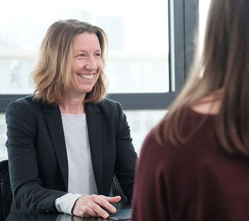 Dr. med. Dr. rer. nat Saskia Biskup lächelt während sie eine genetische Beratung durchführt.